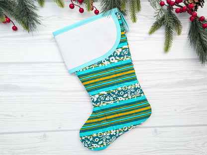 Colorful striped and patterned Christmas stocking on a white wooden surface with holiday decorations.